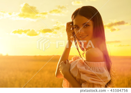 Woman in wheat field at sunset Woman in wheat field at sunset 43384756