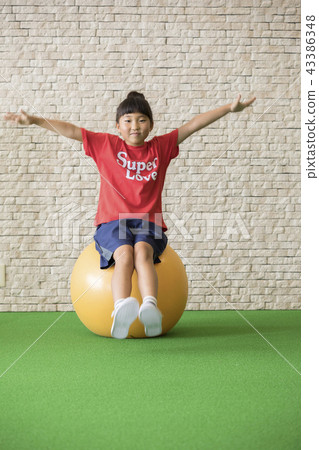 Child riding a balance ball 43386348