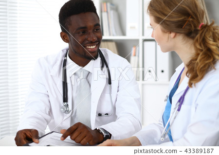Happy african american male doctor with medical staff at the hospital. Medicine concept Happy african american male doctor with medical staff at the hospital. Medicine concept 43389187