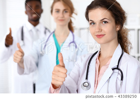 Medical team of confident doctors showing Ok sign with thumbs up. Medicine and health care 43389250