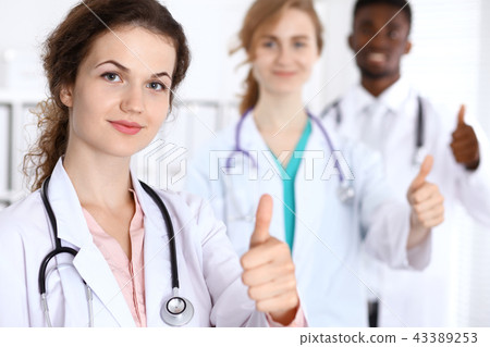 Medical team of confident doctors showing Ok sign with thumbs up. Medicine and health care 43389253