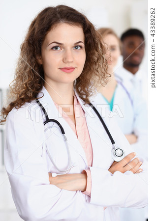Happy doctor woman  with medical staff at the hospital 43389262