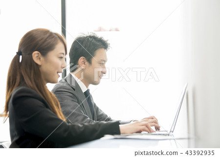 Male and female office workers working on a personal computer Male and female office workers working on a personal computer 43392935