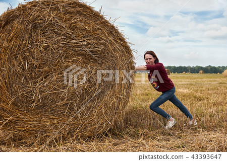 young girl having fun in field with haystack young girl having fun in field with haystack 43393647