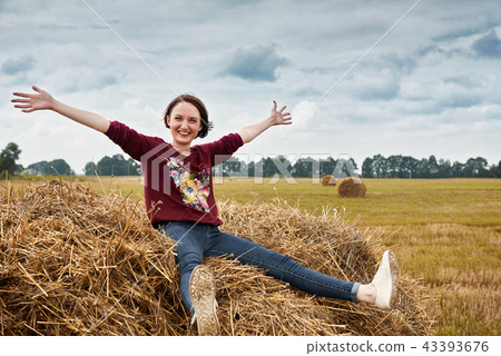young girl having fun in field with haystack 43393676