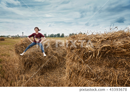 young girl having fun in field with haystack 43393678
