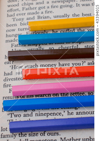 Color pencils placed on the page of a book Color pencils placed on the page of a book 43394015