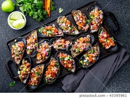 PERUVIAN FOOD. Choros a la chalaca. Big mussels, choros zapatos seasoned with purple onion, tomatoes PERUVIAN FOOD. Choros a la chalaca. Big mussels, choros zapatos seasoned with purple onion, tomatoes 43395961