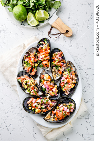 PERUVIAN FOOD. Choros a la chalaca. Big mussels, choros zapatos seasoned with purple onion, tomatoes PERUVIAN FOOD. Choros a la chalaca. Big mussels, choros zapatos seasoned with purple onion, tomatoes 43396026