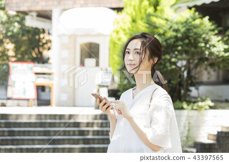 Woman looking at smartphone outdoors 43397565