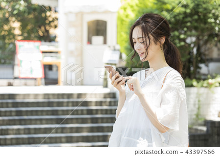 Woman looking at smartphone outdoors 43397566