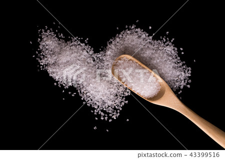 Sea salt in a wooden spoon on a black background Sea salt in a wooden spoon on a black background 43399516