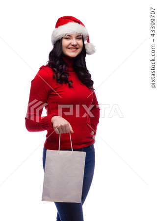 woman wearing christmas hat holding present bag 43399707