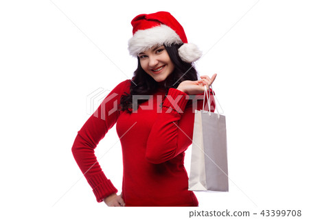 woman wearing christmas hat holding present bag woman wearing christmas hat holding present bag 43399708