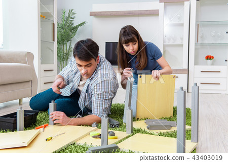 Young family assembling furniture at new house 43403019