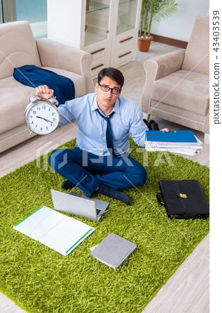 Businessman taking work home and working overtime Businessman taking work home and working overtime 43403539