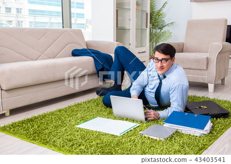 Businessman taking work home and working overtime Businessman taking work home and working overtime 43403541