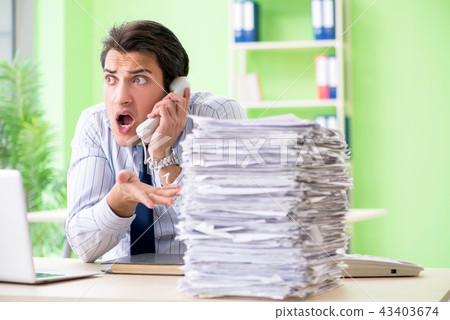 Businessman having problems with paperwork and workload 43403674
