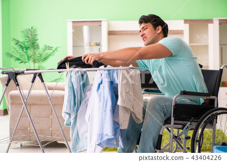 Disabled man on wheelchair doing laundry Disabled man on wheelchair doing laundry 43404226