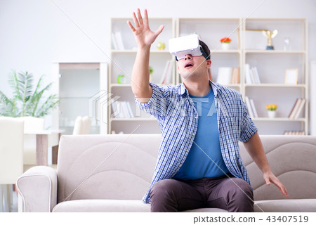 Man with virtual reality glasses playing at home 43407519
