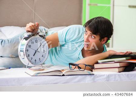 Student preparing for exams at home in bedroom lying on the bed Student preparing for exams at home in bedroom lying on the bed 43407684