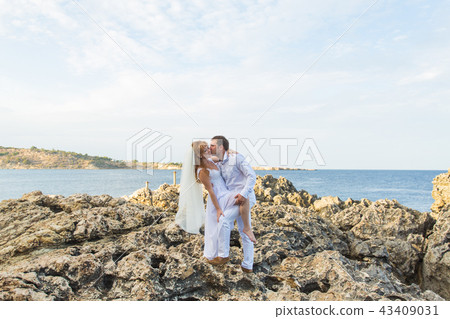 Bride and groom by the sea on their wedding day Bride and groom by the sea on their wedding day 43409031