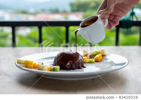 Hot chocolate pouring on cocoa dome dessert 43410319