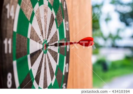 Dart arrow in bullseye target on dartboard 43410394