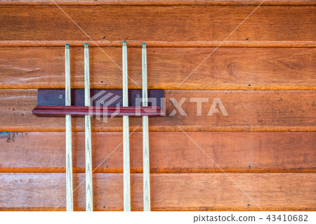 Collection of wooden cue or sticks on wood wall Collection of wooden cue or sticks on wood wall 43410682