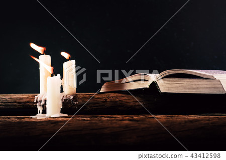 Bible and candle on a old oak wooden table. 43412598
