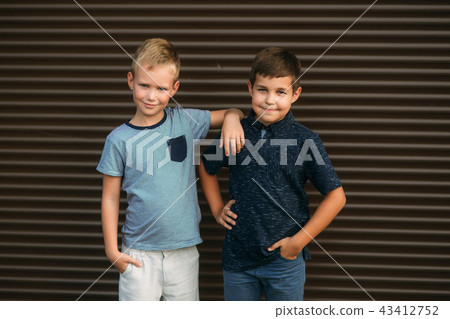 Two stylish childrend posing to the photograher. Youn model Two stylish childrend posing to the photograher. Youn model 43412752
