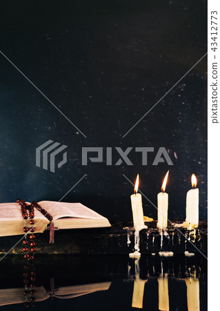 Holy Bible and candle  on a burned wooden table. 43412773
