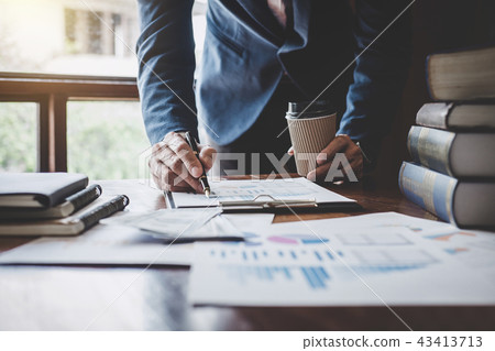 Businessman pointing at graph and chart to analysis use for plan 43413713