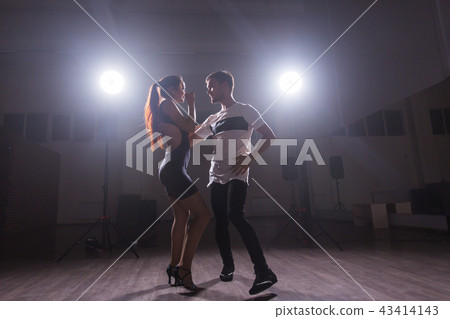 Skillful dancers performing in the dark room under the concert light and smoke. Sensual couple 43414143