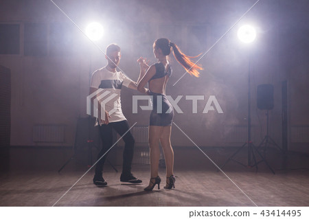 Skillful dancers performing in the dark room under the concert light and smoke. Sensual couple 43414495