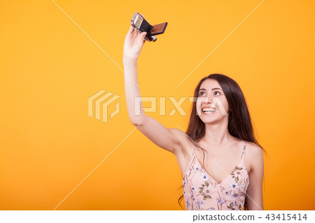 Young beautiful woman playing with toy plane in studio over yellow background Young beautiful woman playing with toy plane in studio over yellow background 43415414