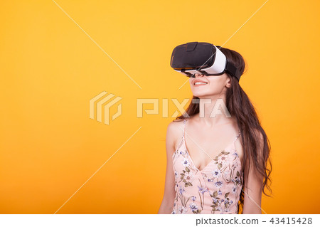 Girl wearing a VR headset and experiencing virtual reality, technology and innovation concept in Girl wearing a VR headset and experiencing virtual reality, technology and innovation concept in 43415428
