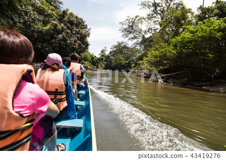 Tourists riding long boat on Merlinau river  43419276