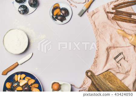 Baking ingredients and tools over pastel lilac background 43424050