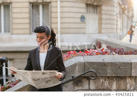 Afro American girl reading newspaper with close up of face. Afro American girl reading newspaper with close up of face. 43425811