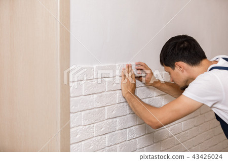 Professional Builder gluing decorative tile on wall. Professional Builder gluing decorative tile on wall. 43426024