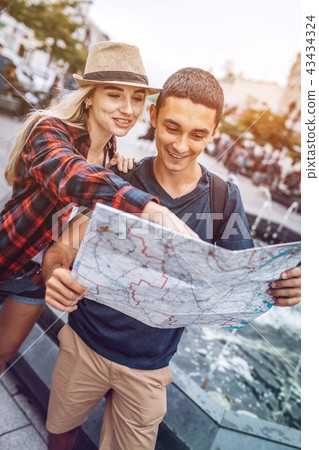 Smiling couple with map traveling in city Smiling couple with map traveling in city 43434324