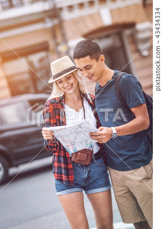 Smiling couple with map on city street Smiling couple with map on city street 43434334