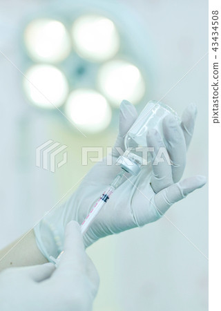 Hand holding syringe and medicine vial Hand holding syringe and medicine vial 43434508