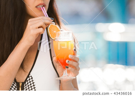 sexy woman by the swimming pool drinking a cocktail sexy woman by the swimming pool drinking a cocktail 43436016