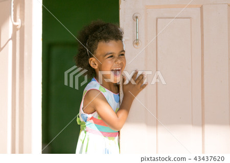 The black girl smiles in the doorway. 43437620