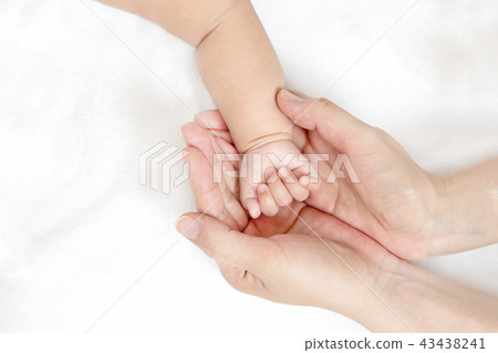 Mom's big hands up with mother's little hands wrapping baby's little hands. Motherhood, affection, happiness, childcare, health image 43438241