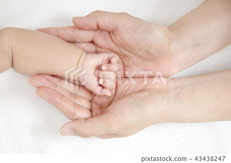 Mom's big hands up with mother's little hands wrapping baby's little hands. Motherhood, affection, happiness, childcare, health image Mom's big hands up with mother's little hands wrapping baby's little hands. Motherhood, affection, happiness, childcare, health image 43438247
