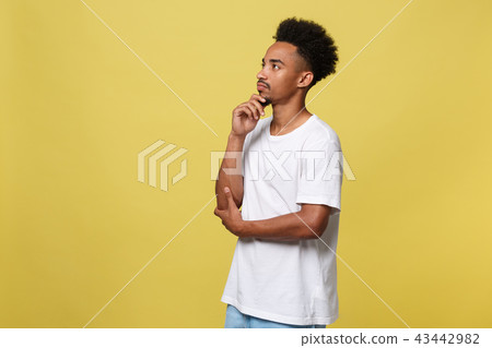 Handsome African-American teenager with casual cloth isolated on yellow background. Handsome African-American teenager with casual cloth isolated on yellow background. 43442982
