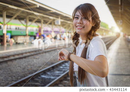woman check time waiting train on railway station. woman check time waiting train on railway station. 43443114